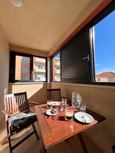 a dining room table with two chairs and windows at Apartment Agata in Trogir