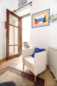 a living room with a white chair and a window at Studio in the Old City of Nicosia in Nicosia