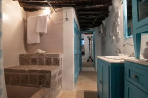 ein Badezimmer mit blauen Schränken und einem Waschbecken in der Unterkunft Historical Stone Manor-Ground floor in Hydra