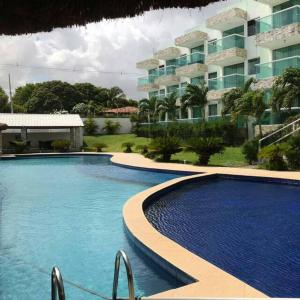 a large swimming pool in front of a building at apartamento em Jacumã in Jacumã