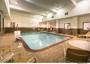 ウィネマッカにあるHoliday Inn Express Winnemucca, an IHG Hotelのテーブルと椅子付きのホテルルーム内の大きなプールを提供しています。