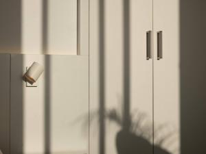 una sombra de una lámpara en un armario blanco en Finca Las Huellas - Moderno apartamento con vistas al mar y al volcán, en Los Llanos de Aridane