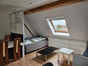 ein kleines Schlafzimmer im Dachgeschoss mit einem Bett und einem Fenster in der Unterkunft Apartment Home 3 in Schwabach