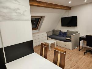 ein kleines Wohnzimmer mit einem Sofa und einem TV in der Unterkunft Apartment Home 3 in Schwabach
