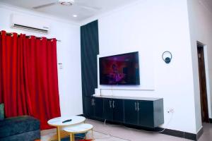 a living room with red curtains and a tv at Kazi apartment in Dar es Salaam