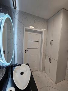 a bathroom with a white toilet and a mirror at Apartament - Osiedle Przylesie in Namysłów