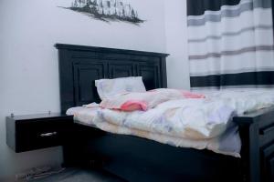 a bedroom with a bed with a black headboard at Kazi apartment in Dar es Salaam