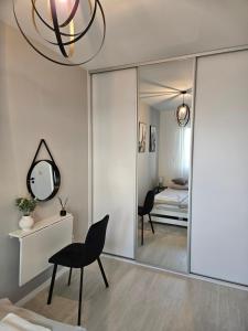 een kamer met een spiegel, een stoel en een bed bij Apartament - Osiedle Przylesie in Namysłów