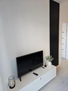 a living room with a flat screen tv on a white cabinet at Apartament - Osiedle Przylesie in Namysłów