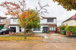 une maison blanche avec un arbre dans l'allée dans l'établissement Gorgeous House in Sidcup, à Streatham Hill