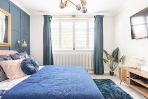 a bedroom with a blue bed and a window at Gorgeous House in Sidcup in Streatham Hill