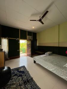 een slaapkamer met 2 bedden en een plafondventilator bij Resort Green Earth in Tajpur