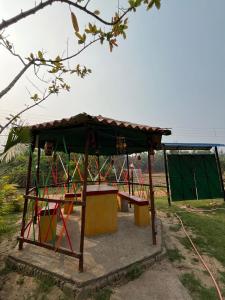 a park with a bench and a pavilion at Resort Green Earth in Tajpur