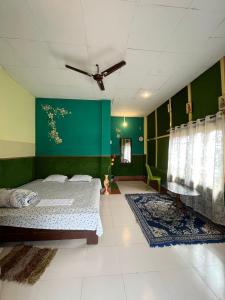 een slaapkamer met een bed en een groene muur bij Resort Green Earth in Tajpur