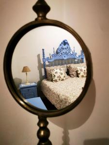 un miroir reflétant un lit avec une tête de lit bleue dans l'établissement Charming Portuguese style apartment, for rent "Vida à Portuguesa", "Sardinha" Alojamento Local, à Portimão