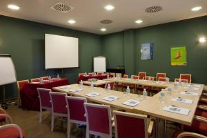 una sala conferenze con tavoli, sedie e schermo di Holiday Inn Express Madrid-Getafe, an IHG Hotel a Getafe
