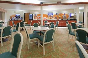 a waiting room with tables and chairs at Holiday Inn Express & Suites Colorado Springs-Airport, an IHG Hotel in Colorado Springs