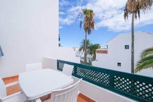 een balkon met een witte tafel en palmbomen bij Duplex Beach & Pool, La Palma in Los Cancajos