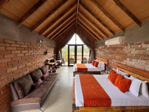 a room with two beds and a brick wall at Don Tomas Viñedo cabañas in Valle de Guadalupe