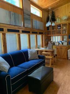 a living room with a blue couch and a table at Knotty but Nice-sleeps 6-one minute to lake! in Three Oaks +33 photos
