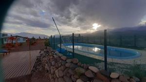 a swimming pool with a fence and a rock wall at La Chakana in Uspallata