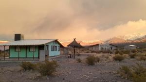 a house in the desert with mountains in the background at La Chakana in Uspallata