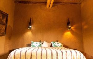 Un dormitorio con una cama con almohadas. en JNANE ZOHRA en Taroudant