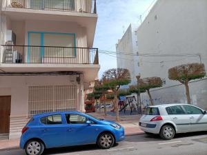 two cars parked on a street next to a building at La Cubana II con Aire Acondicionado in Santa Pola