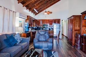 a living room with a couch and a kitchen at Tres Cocos Resort in San Pedro