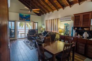 a living room with a table and a kitchen at Tres Cocos Resort in San Pedro