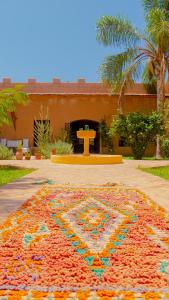 una alfombra grande y colorida en el suelo frente a un edificio en JNANE ZOHRA, en Taroudant