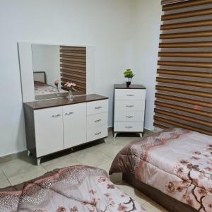 een slaapkamer met 2 bedden en een spiegel bij 2 bedrooms apartment no 18 in Amman