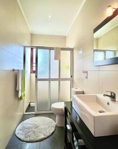 a bathroom with a sink and a toilet and a window at Vista Montanha in Madalena