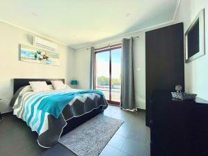 a bedroom with a bed and a large window at Vista Montanha in Madalena