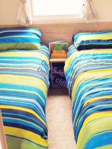 two beds sitting next to each other in a room at 3 Bedroom Deluxe Caravan at Haven Devon Cliffs in Exmouth