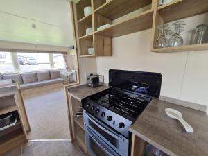 a kitchen with a stove and a counter top at 3 Bedroom Deluxe Caravan at Haven Devon Cliffs in Exmouth