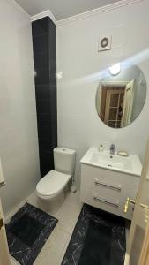 a bathroom with a white toilet and a mirror at Apartment for rent in Căușeni in Căuşeni