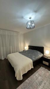 a bedroom with a bed and a chandelier at Apartment for rent in Căușeni 2 in Căuşeni
