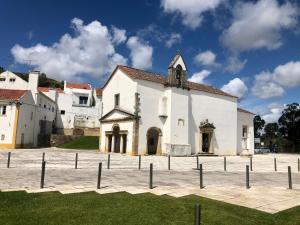 eine große weiße Kirche mit einem Zaun davor in der Unterkunft Apartamento T1 no centro TÊ-U in Torres Vedras