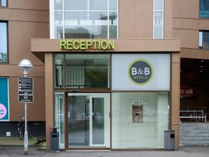 B&B HOTEL Vejle في فيجلي: واجهة متجر عليها لافتة مكتوب عليها الاستقبال