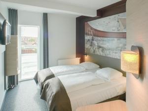 um quarto de hotel com uma cama e uma grande janela em B&B HOTEL Vejle em Vejle