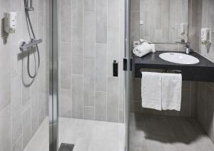 La salle de bains est pourvue d'une douche et d'un lavabo. dans l'établissement B&B HOTEL Vejle, à Vejle