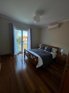 a bedroom with a large bed and a large window at Wanderlust House in Ponta Delgada