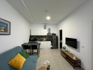 a living room with a blue couch and a kitchen at Casa Sofia - Costa Calma Sun & Beach in Costa Calma