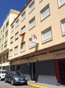 a building with a car parked in front of it at Hostal Ripoll Ibiza in Ibiza Town