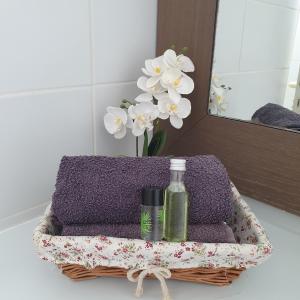 a lavender towel with a bottle of soap and flowers at Studio Paradis 3* in Saint-François