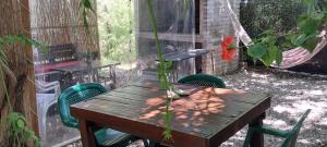 une table en bois avec des chaises et un hamac dans la cour. dans l'établissement Gotas de Rocio, à Piriápolis