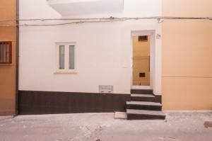 una scala che conduce a una porta in un edificio di Il Vittoria - Self Check in a Lascari