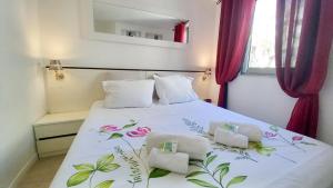 a bedroom with a white bed with flowers on it at Les Félibriges in Cannes