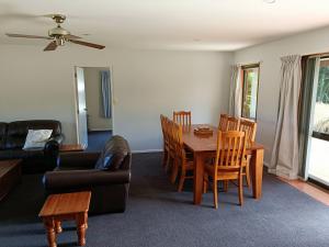 ein Wohnzimmer mit einem Tisch, Stühlen und einem Sofa in der Unterkunft 130 Jacks Pass Rd in Hanmer Springs